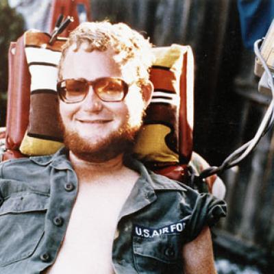 Image is of Sam Provence as a young man in a jean jacket wearing sunglasses.